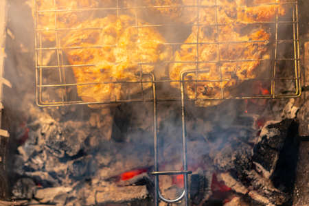 barbecue on the grill. meat on a skewer. cooking meat on fire. Skewers of meat outdoors. Man cooking marinated shashlik, lamb meat grilling on metal skewer. Flames of Fire In The Backgroundの写真素材