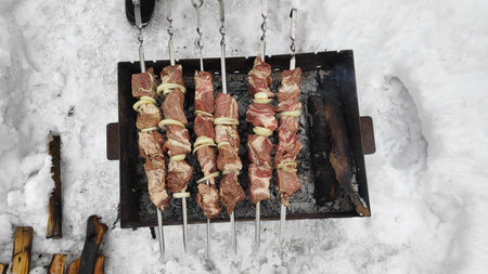 barbecue on the grill. meat on a skewer. cooking meat on fire. Skewers of meat outdoors. Man cooking...