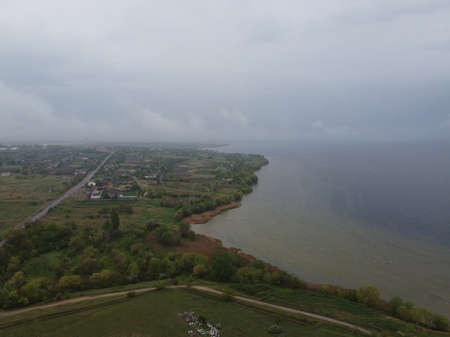 landscape with water from above. Aerial view of sandy beach and ocean with waves. Photo taken by a drone from above. natural landscape. Aerial view of a green grassy forest.の写真素材