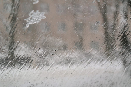 snow melts on glass. snowflakes on the glass of a car. raindrops behind glass. window in wet snow....