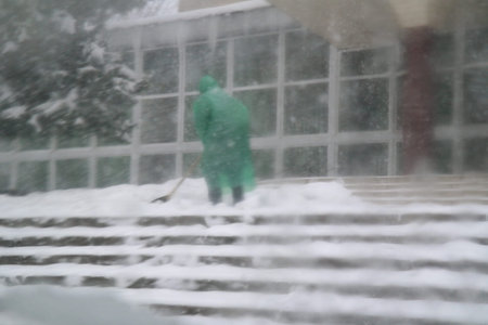 snow removal. people shovel snow. snow on the steps. man and woman with a shovel. Blizzard. bad weather. abstraction. blurred background.の写真素材