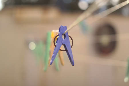 old pegs on a rope. One old retro clothespin wooden on a linen rope. Work on the house, washing, drying linen. Old Dirty Blue and Pink clothes peg on a rope Wire isolated on blurred backgroundの写真素材