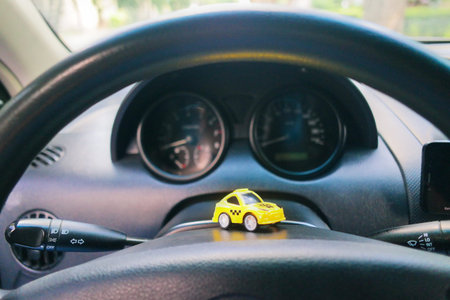 toy car in a big car. small taxi car. yellow taxi. public transport. concept toy taxi car.