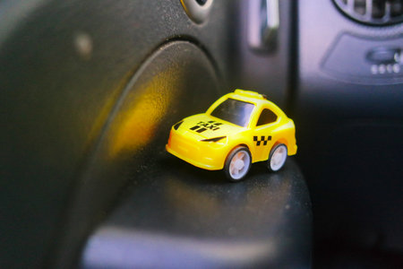 toy car in a big car. small taxi car. yellow taxi. public transport. concept toy taxi car.の写真素材