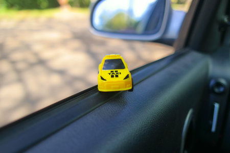 toy car in a big car. small taxi car. yellow taxi. public transport. concept toy taxi car.