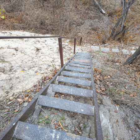 old iron stairs. rusty metal stairs. dangerous steep vintage stairs. descent from the mountain.の写真素材