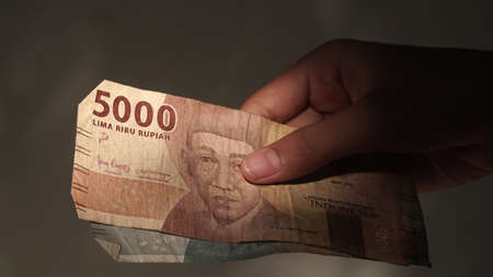 Indonesian rupiah banknotes, 5,000 rupiah, held by girlsの写真素材