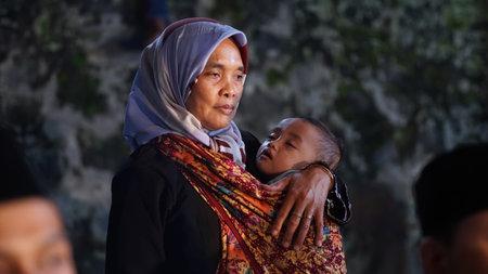 Yogyakarta, Indonesia. April 24, 2019. The little boy fell asleep in his mother's arms. Focus is...