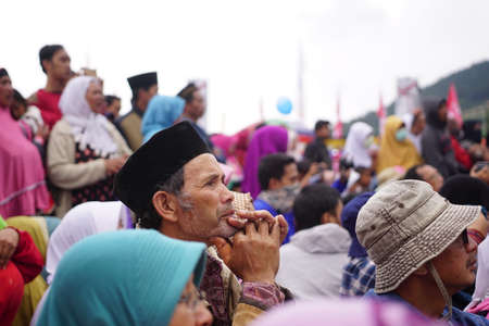 Wonosobo, Indonesia. August 5, 2016. Old Muslim man in black cap in a crowd at a religious event. Selected focusのeditorial素材