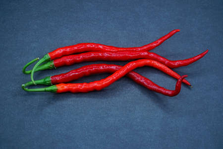 Four red chili pepper isolated on a black background, focus selectedの写真素材