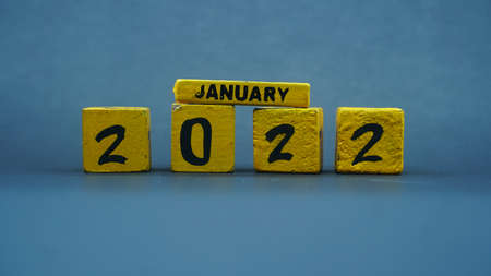 Wooden block calendar for January 2022. Yellow on a dark backgroundの写真素材