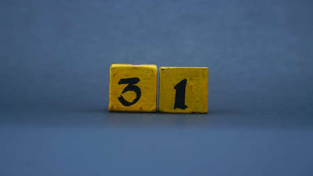 Wooden block with number 31. Yellow color on dark backgroundの写真素材