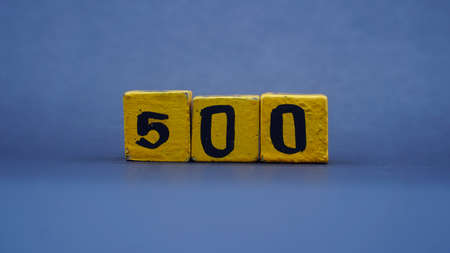 Wooden block with number 500. Yellow color on dark background. Focus selectedの写真素材