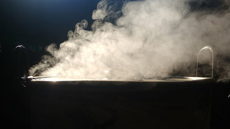 Smoke rose from the pot that was boiling water. black background