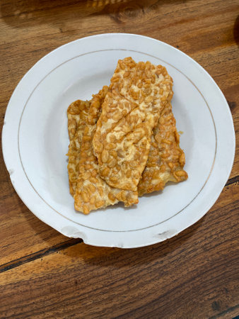 Fried tempeh on a plate on a wooden tableの写真素材