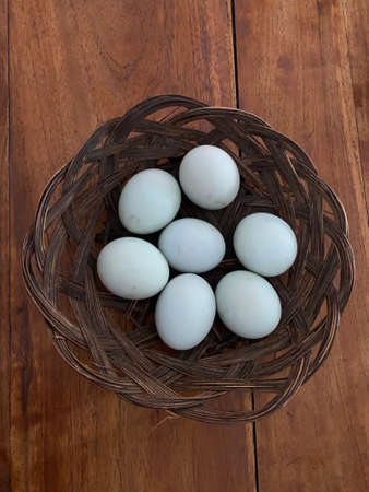 Salted eggs in basket on wooden tableの写真素材