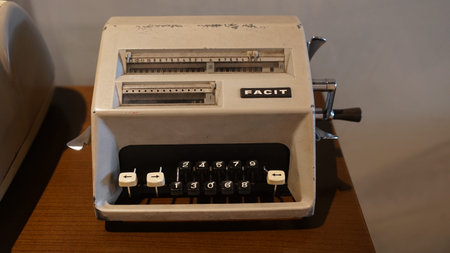 Brown antique calculating machine on wooden table. Focus is selected. Blurred backgroundの写真素材