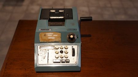 Blue antique calculating machine on wooden table. Focus is selected. Blurred backgroundの写真素材