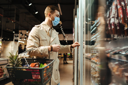 Man shopping in supermarket in mask during quarantine