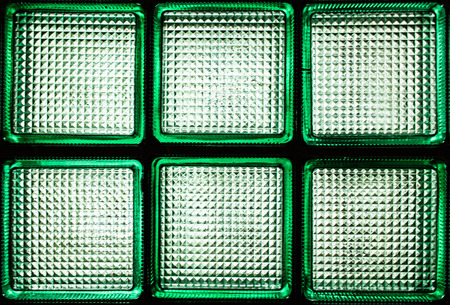 Six green transparent glass blocks. A fragment of a glass wall with daylight passing through it.の写真素材