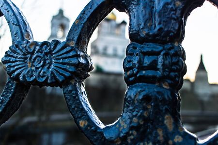 A fragment of cast-iron fencing against the background of an ancient fortress and a cathedral of the Holy Trinity.のeditorial素材
