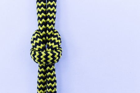 Two striped yellow and black ropes with knot isolated on white backfroundの写真素材