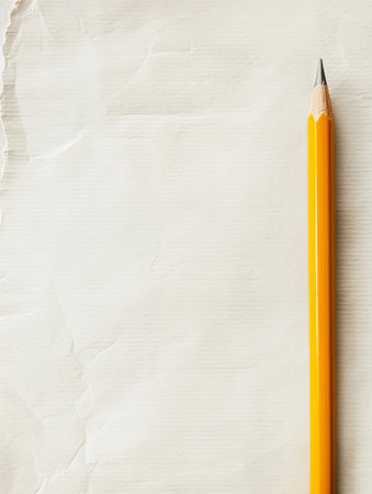 Yellow pencil on textured paper. Simple setup for writing or sketching themes, perfect for education or creative designs. Ideal for school or artistic visuals.の素材