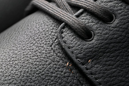 Dark leather shoe with lace-up front. Detailed view of high-quality shoe material. Ideal for elegant fashion or product shoot.の素材