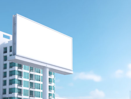 Clear billboard with a blue sky and city skyline, suitable for advertising messages and corporate branding in a dynamic urban setting.の素材