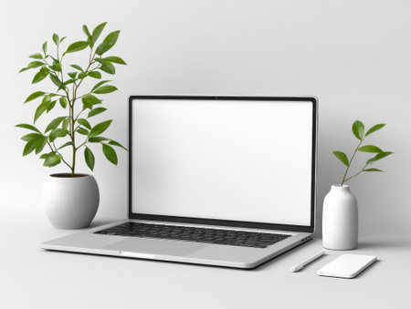 Laptop with clear screen on desk with greenery and mug. Ideal for workspace design, it features a fresh office look. Perfect for professionals.の素材