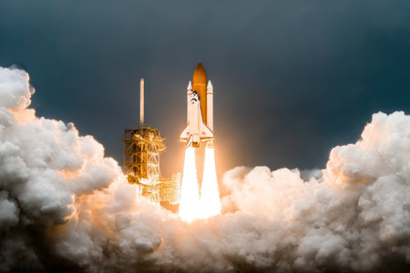 Space Shuttle launch from a launch pad, powerful rocket rising high into dark sky with huge smoke clouds and fire trail. Successful Space Shuttle mission start, cosmic flight start, space travel.の素材
