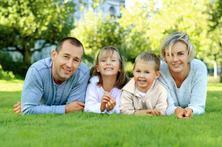Family lying on the grass and smilingの写真素材
