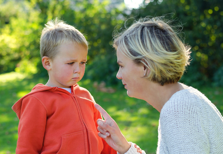 Mother scolds her son crying in the parkの写真素材