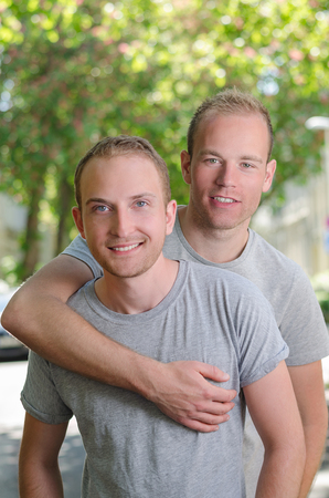 Two  guys walking on a street at the spring, portrait how they happy smiling and huggingの写真素材