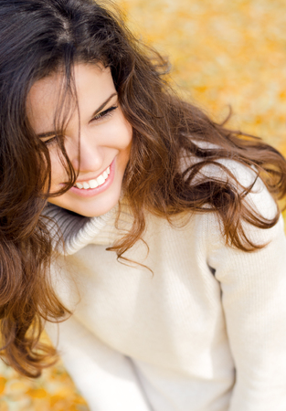 Close up portrait of a happy beautiful woman in autumnの写真素材