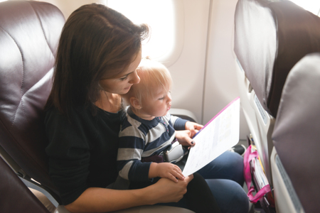 Mother and ner daughter  checking safety  in economy class airliner の写真素材