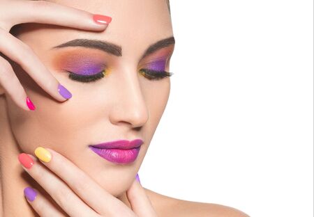 Beautiful  woman with multicolor nails and fashion makeup isolated on whiteの写真素材