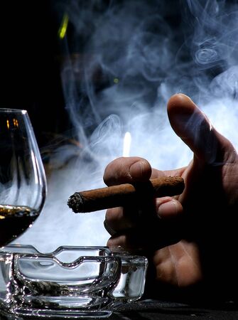 Hand with a cigar and a cognac glassの写真素材