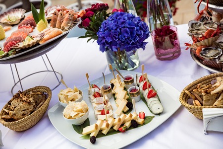 Cheese with pear and strawberries lie on plateの写真素材