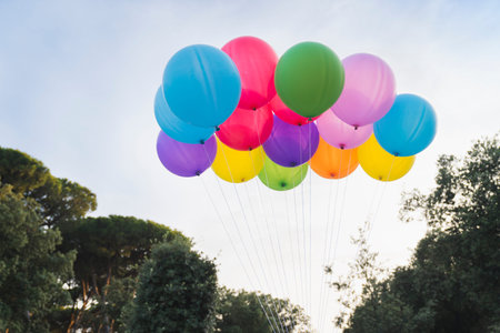 Colorful helium balloons on sky background, summer party concept