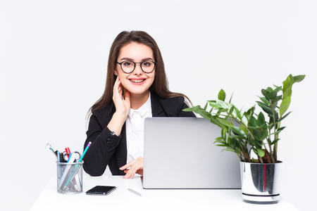 Young successful employee working with her laptop at modern white office. White backgroundの写真素材