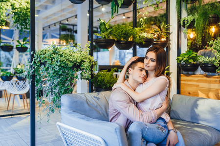 The guy and the girl are hugging in the cafe.の写真素材