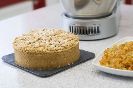 Candied pie on the kitchen table. In the background a food processor.の写真素材