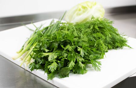 Fresh herbs on a cutting board ready to cookの写真素材