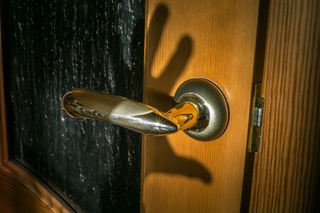 hand shadow at door handle. home security.の写真素材