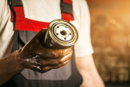 Mechanic. Dirty hands holding oil filter.の写真素材