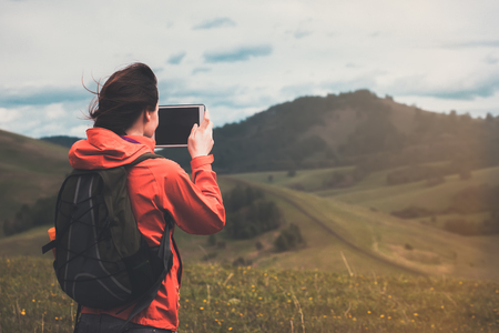  backpacker girl taking photo with digital tablet の写真素材