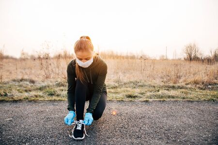 COVID-19 Pandemic Coronavirus girl in mask and blue gloves during quarantine went out to runの写真素材