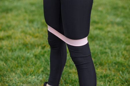 fitness rubber on the legs of a girl who does sports on the streetの写真素材