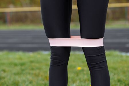 fitness rubber on the legs of a girl who does sports on the streetの写真素材